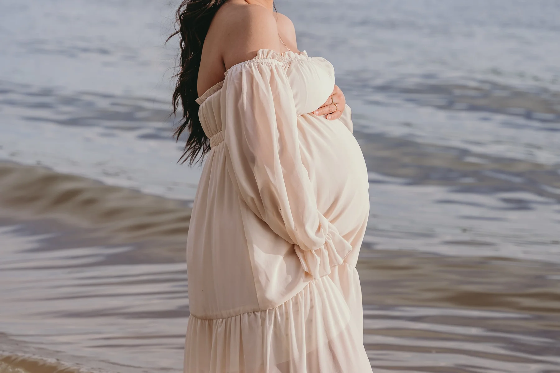 A serene maternity session by the water — soft light and natural beauty